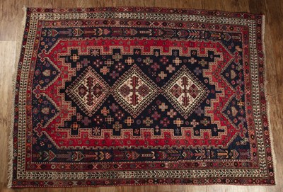 Lot 147 - Red and blue ground rug with three central...