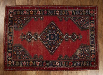 Lot 148 - Caucasian red ground small rug with a central...