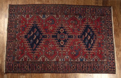 Lot 150 - Caucasian red ground rug with three medallions...