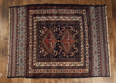 Lot 34 - Tribal-style wool rug navy ground, decorated...