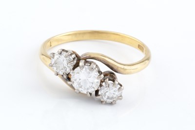 Lot 128 - A diamond three stone ring, of crossover...