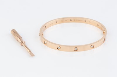Lot 260 - A diamond set 'Love' bangle by Cartier, of...