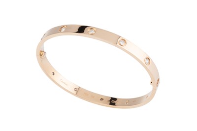 Lot 260 - A diamond set 'Love' bangle by Cartier, of...