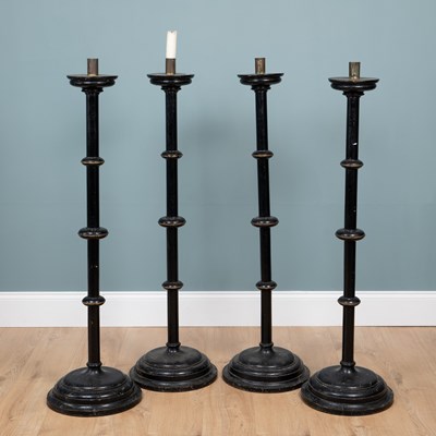 Lot 314 - A set of four Aesthetic Movement ebonised floor-standing candlesticks