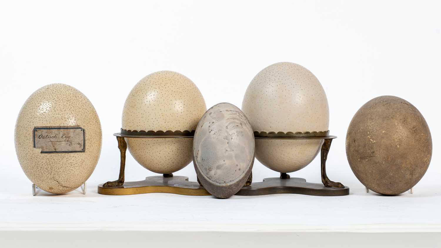 Lot 1281 - A pair of ostrich eggs on decorative brass mounts