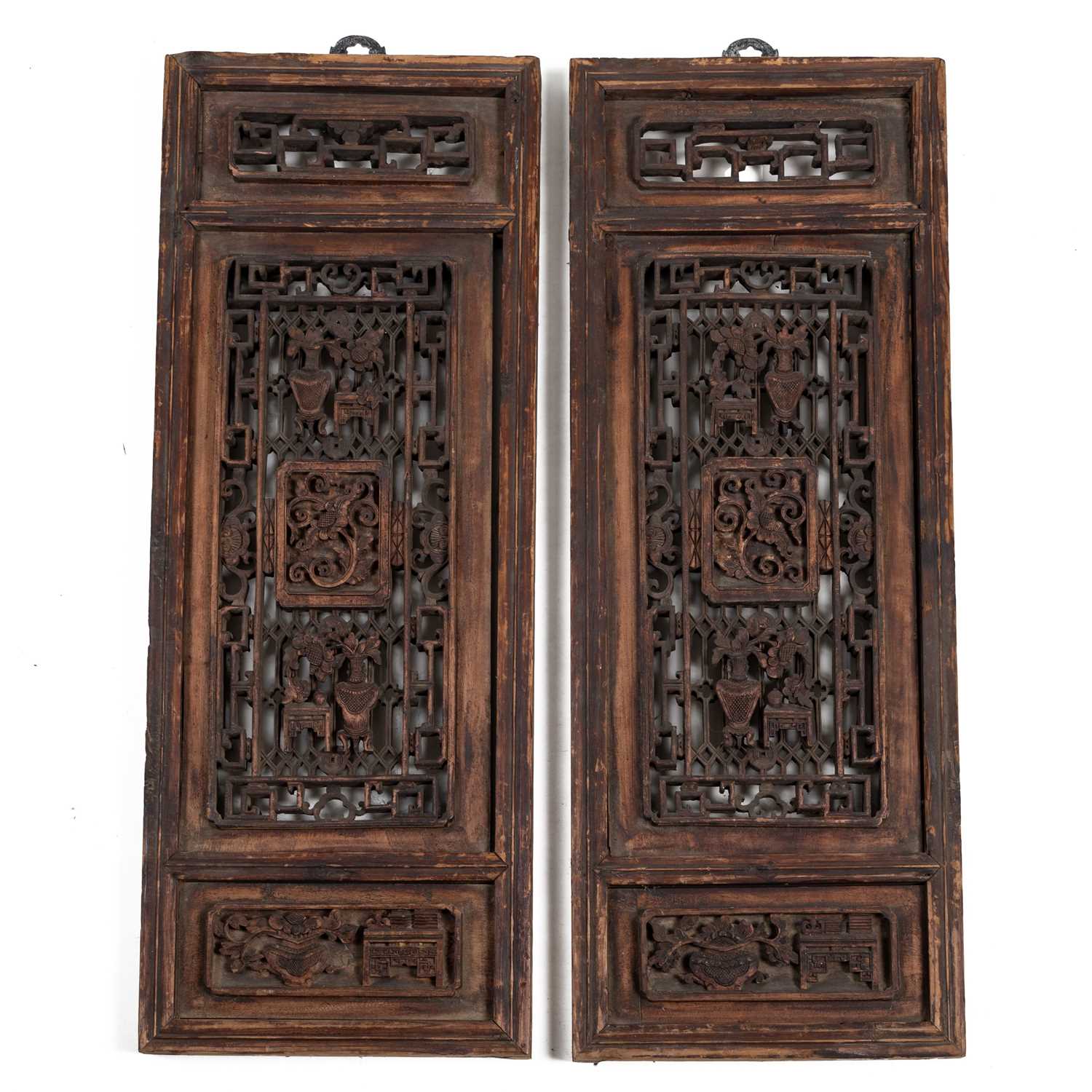 Lot 384 - A pair of Oriental hardwood carved panels.