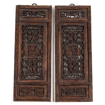 Lot 384 - A pair of Oriental hardwood carved panels.