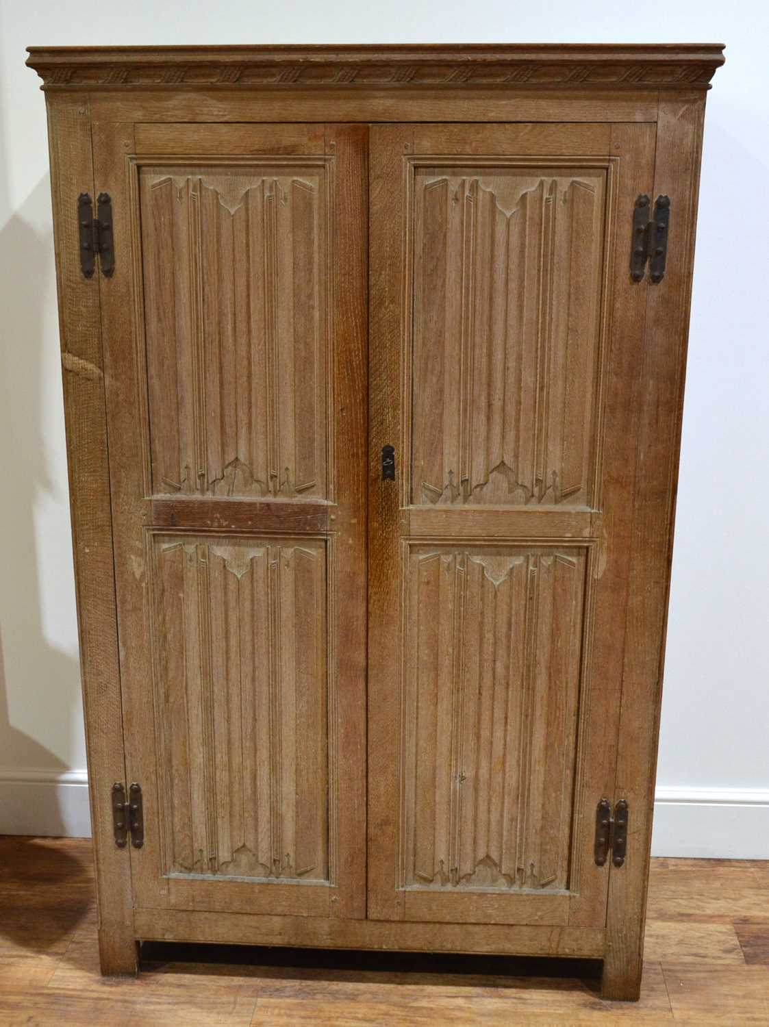 Lot 65 - Limed oak linen fold cupboard with iron hinges...