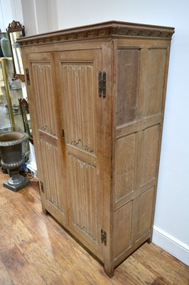 Lot 65 - Limed oak linen fold cupboard with iron hinges...