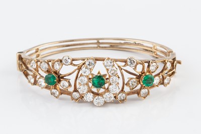 Lot 96 - An emerald and diamond bangle, of hinged oval...