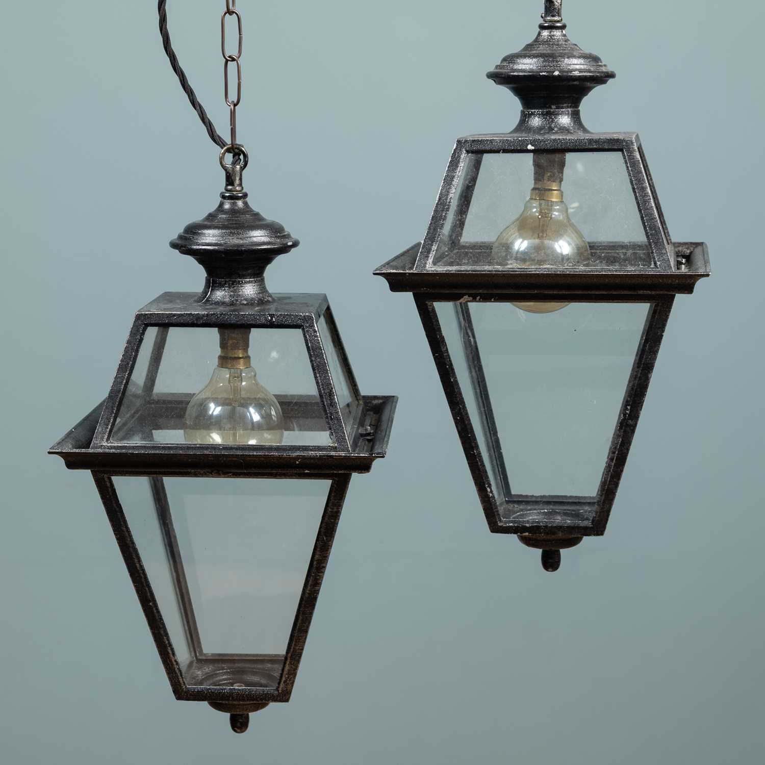 Lot 560 - A pair of black-painted cast aluminium lanterns
