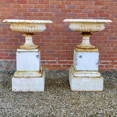 Lot 1443 - A pair of antique cast iron urns on stepped plinth bases