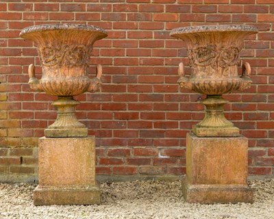 Lot 1328 - A pair of terracotta coloured cast urns and plinths
