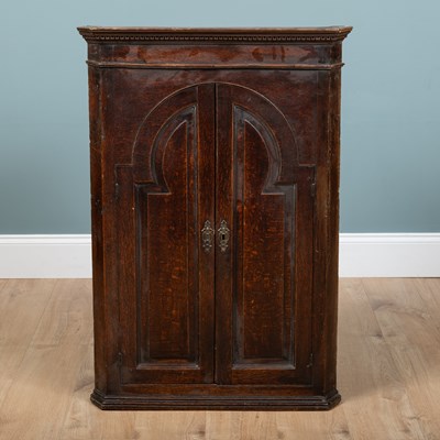 Lot 1095 - A George III oak corner cupboard