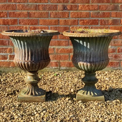 Lot 1430 - A pair of campana-style cast iron urns