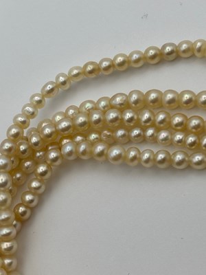 Lot 129 - A multi-strand pearl necklace with diamond set...