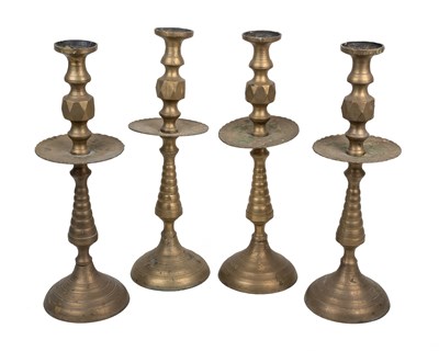 Lot 1185 - A set of four turned brass candlesticks