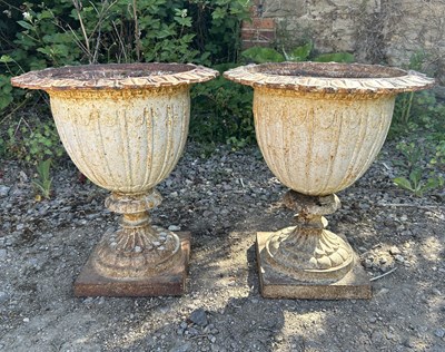Lot 1386 - A pair of white-painted cast iron garden urns