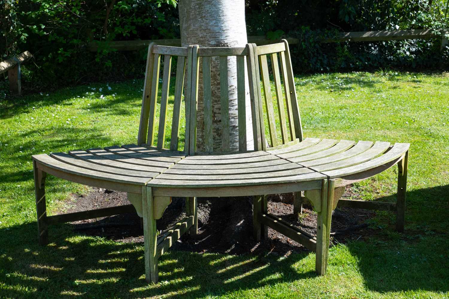 Lot 1450 - A curving teak tree seat