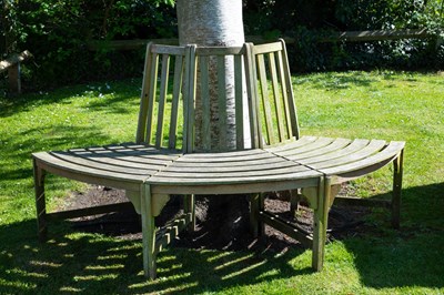 Lot 1450 - A curving teak tree seat