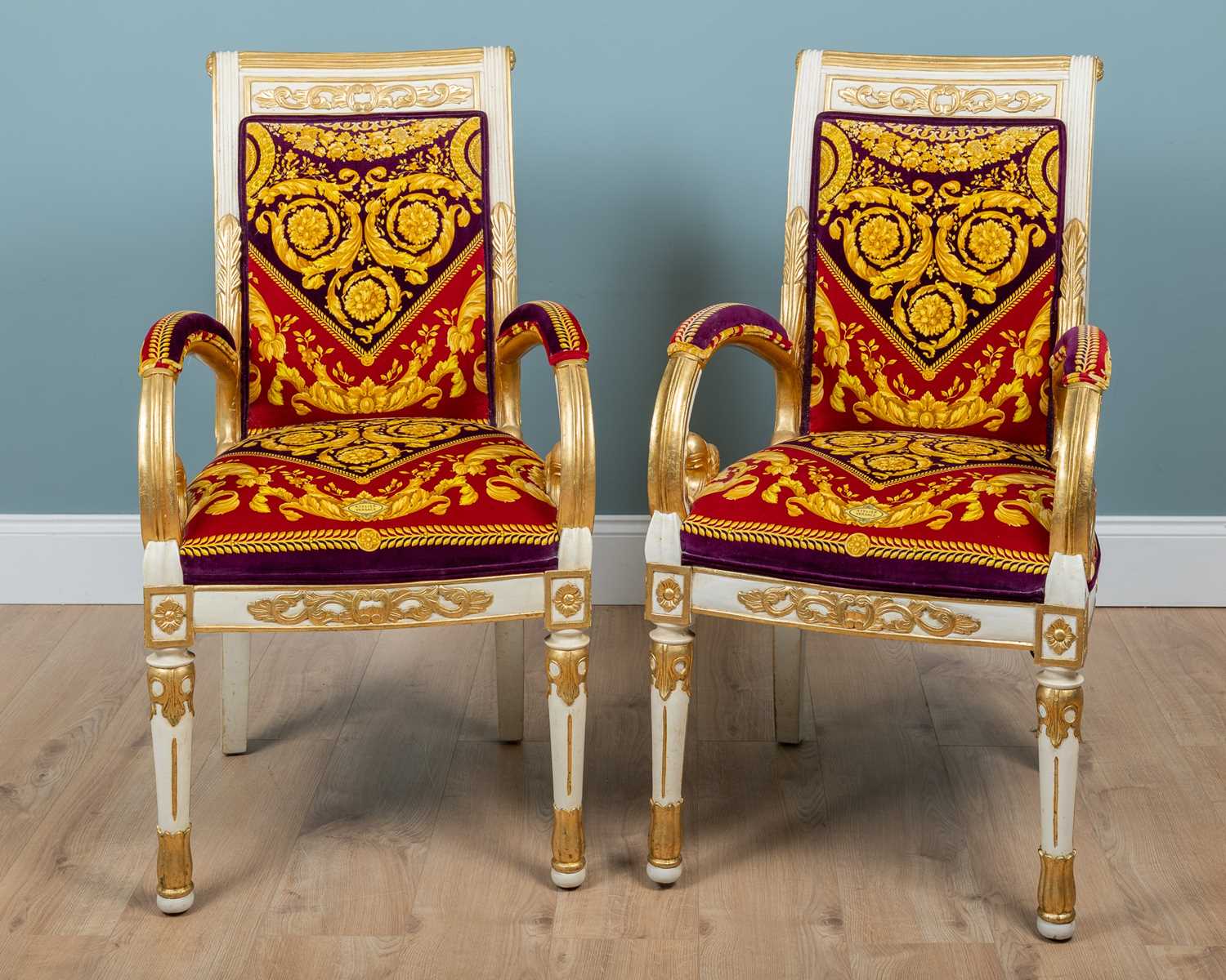Lot 127 - A pair of Atelier Versace Neoclassical-style gilt and white-painted armchairs