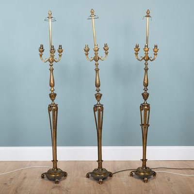 Lot 453 - A set of three cast brass floor lamps