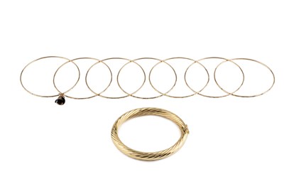 Lot 80 - A hinged oval bangle, of twisted design,...