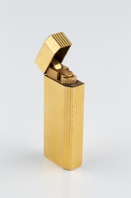 Lot 235 - A gold plated lighter by Cartier, of reeded...