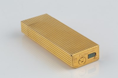 Lot 235 - A gold plated lighter by Cartier, of reeded...
