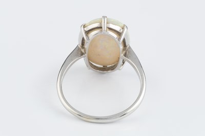 Lot An opal single stone ring, the oval cabochon...
