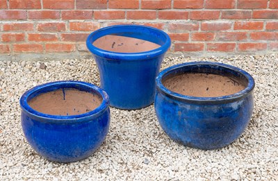 Lot 1343 - A group of three blue glazed garden pots