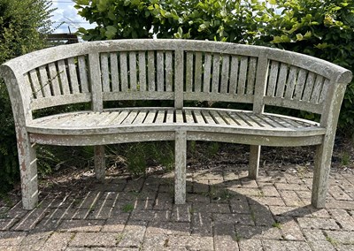 Lot 1268 - A teak banana-shaped bench