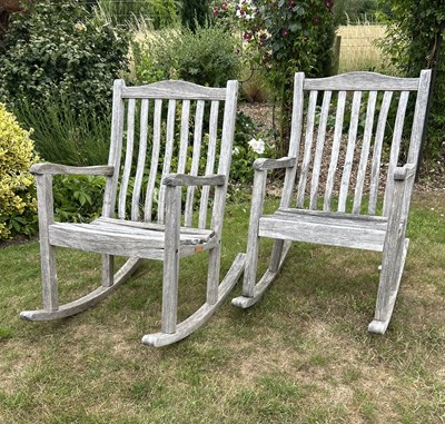 Lot 1297 - Two teak garden rocking chairs