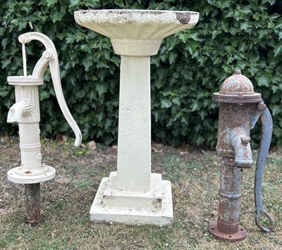 Lot 1261 - An old birdbath and two cast iron barrel pumps
