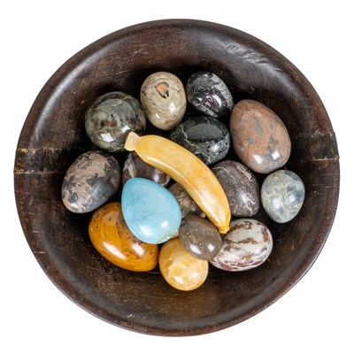 Lot 1202 - A collection of hardstone eggs in a rustic bowl
