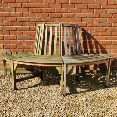 Lot 1479 - A teak half-round tree bench