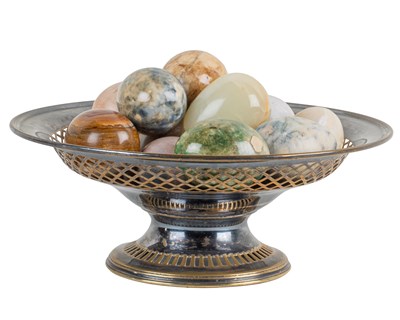Lot 1310 - A collection of hardstone eggs in a silver-plated dish