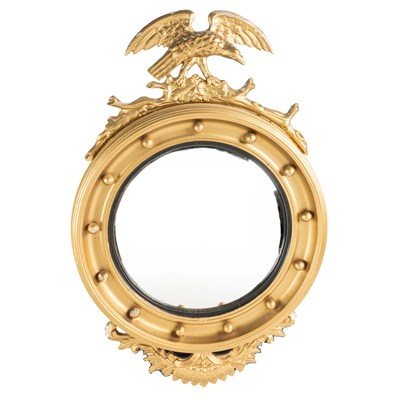 Lot 496 - A gilt convex wall mirror with an eagle crest