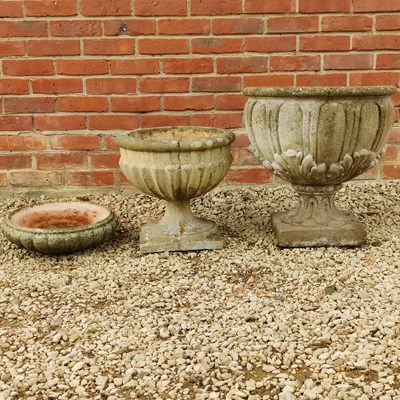Lot 1407 - Two cast composite garden urns and a birdbath
