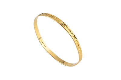 Lot 8 - A 22ct gold bangle, with engraved decoration...