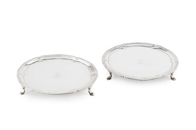 Lot 868 - A matched pair of George III silver waiters,...