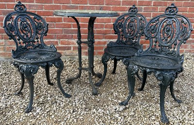Lot 1104 - An antique cast iron table with circular inset stone top together with three cast iron chairs