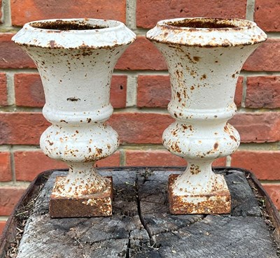 Lot 1089 - A pair of miniature white-painted camana urns