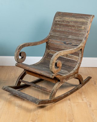 Lot 1087 - A teak garden rocking open armchair