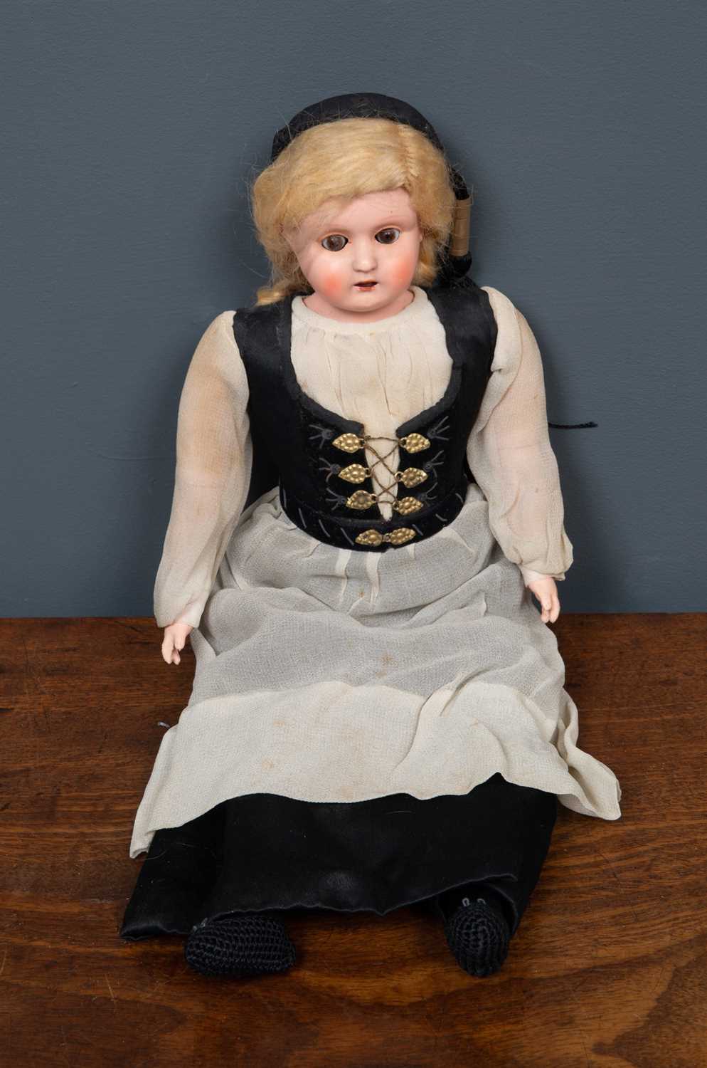 Lot 136 - A vintage doll with rolling eyes in black and...