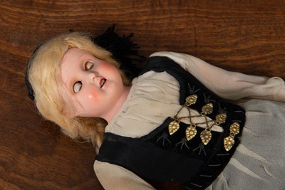Lot 136 - A vintage doll with rolling eyes in black and...