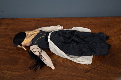 Lot 136 - A vintage doll with rolling eyes in black and...
