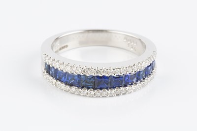 Lot 177 - A sapphire and diamond half hoop ring, centred...