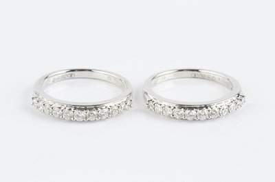 Lot 143 - A pair of diamond half hoop rings, each with a...