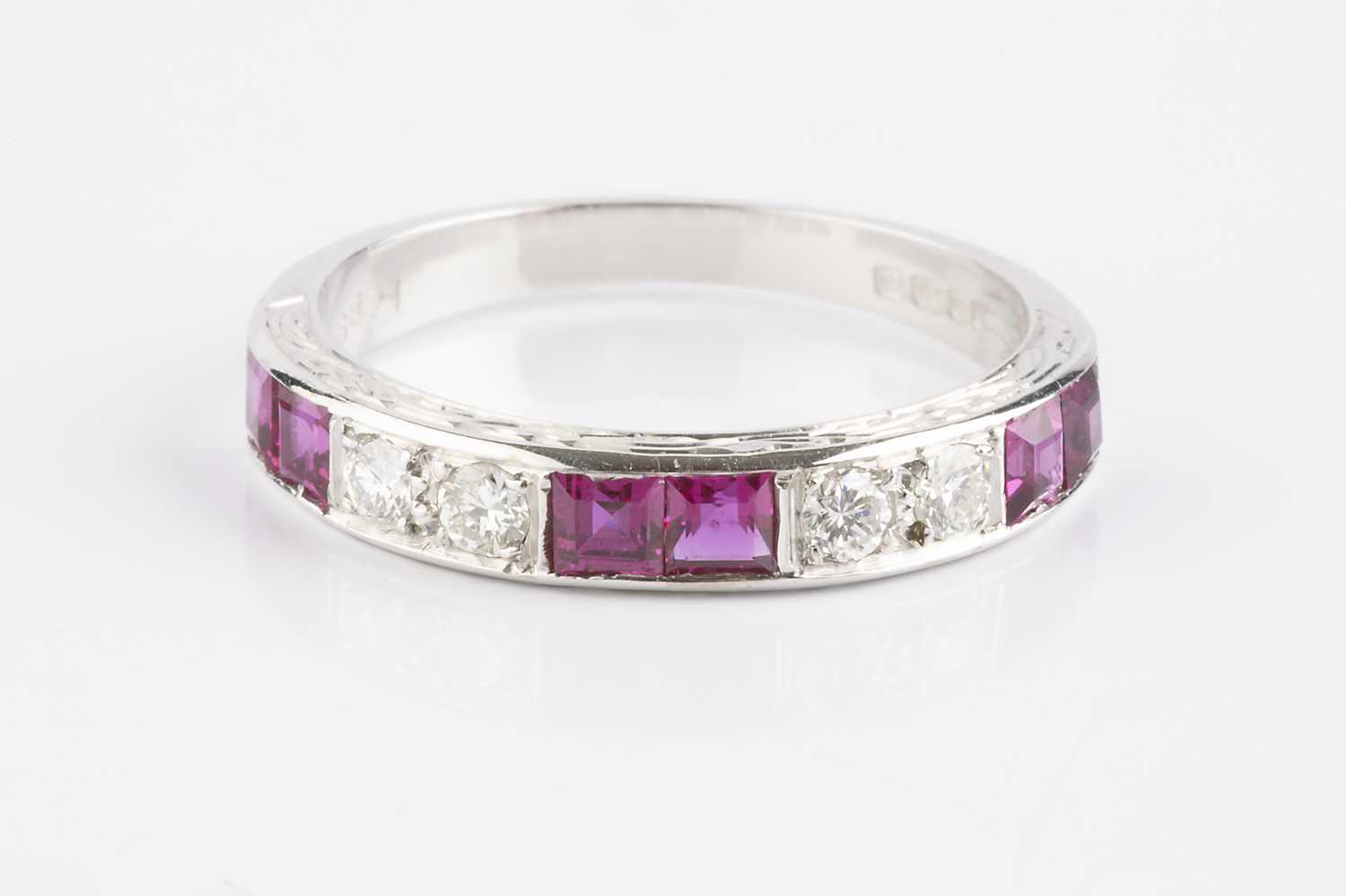 Lot 138 - A ruby and diamond half hoop ring, alternately...
